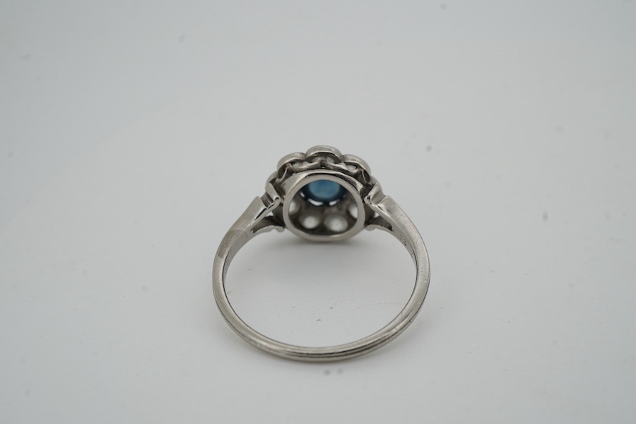 A sapphire and diamond cluster ring, early 20th century, set with a cabochon sapphire measuring approximately 5 x 5 x 3mm, within a border of circular-cut diamonds totalling approximately 0.90 carats, size M, gross weigh